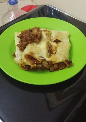 A picture of Lasagna rolls coated with cheese.