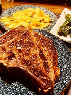 Una foto de Chuleta de vaca gallega madurada, con patatas y pimientos de Padrón