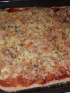 Una foto de Pizza casera de jamón y queso