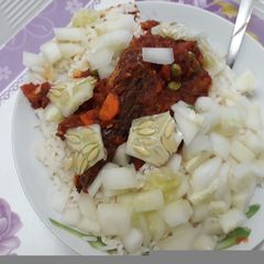 A picture of White rice with stew,cucumber and carrots.