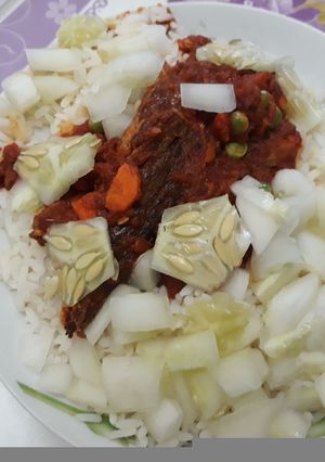 A picture of White rice with stew,cucumber and carrots.
