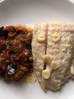 Una foto de Perca a la plancha con pisto de verduras y ajo