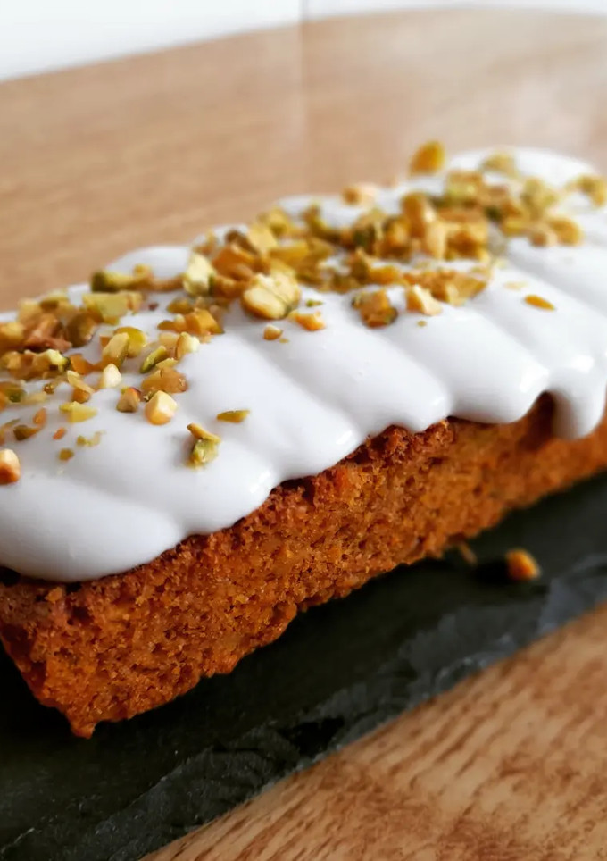 Una foto de Tarta de zanahoria y pistachos con frosting de coco
