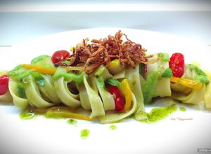 Foto di Tagliatelle con crema di piselli e basilico, peperoni e cipolla fritta