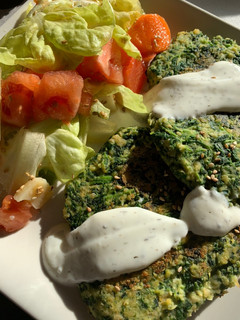 Una foto de Hamburguesa de garbanzos y espinacas con salsa de yogur, acompañado de ensalada🥬🍅🧀