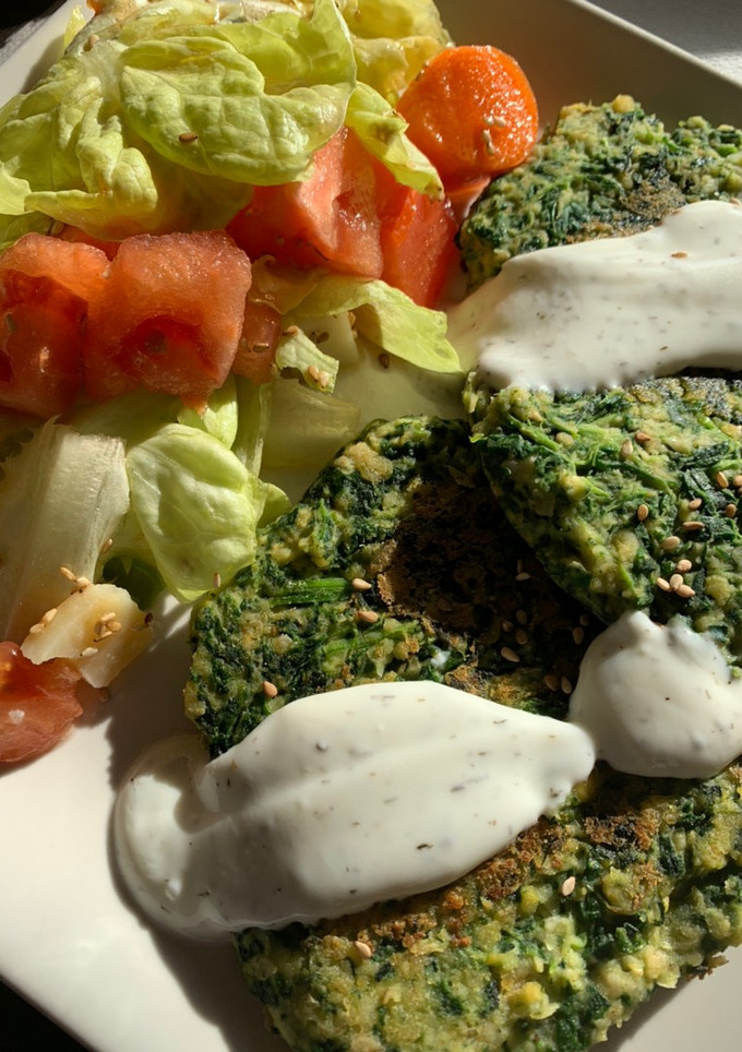 Una foto de Hamburguesa de garbanzos y espinacas con salsa de yogur, acompañado de ensalada🥬🍅🧀