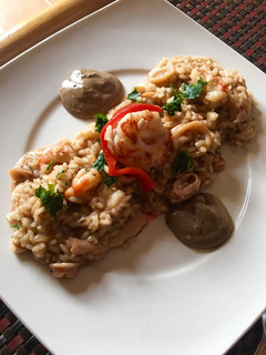 Una foto de Risotto de gambones y chipirones con mayonesa de ajo negro