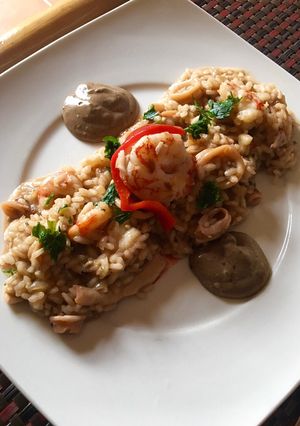 Una foto de Risotto de gambones y chipirones con mayonesa de ajo negro