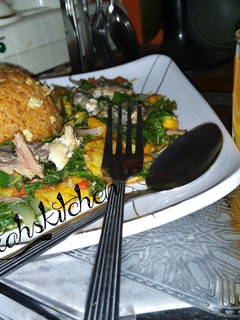A picture of Party jollof rice with sweetpotatoes and spinach sauce.