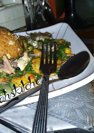 A picture of Party jollof rice with sweetpotatoes and spinach sauce.