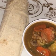 A picture of Chicken soup with bread.