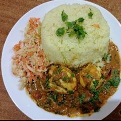 A picture of Egg curry with tumeric rice.