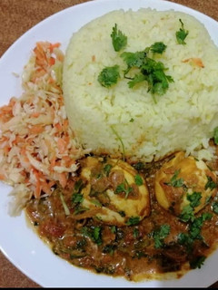 A picture of Egg curry with tumeric rice.