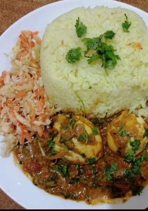 A picture of Egg curry with tumeric rice.