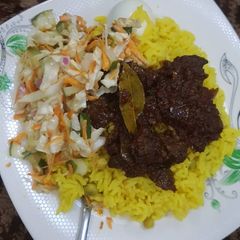 A picture of Rice and liver sauce with coleslaw.