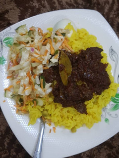 A picture of Rice and liver sauce with coleslaw.