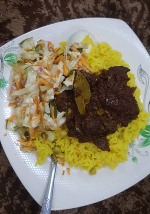 A picture of Rice and liver sauce with coleslaw.