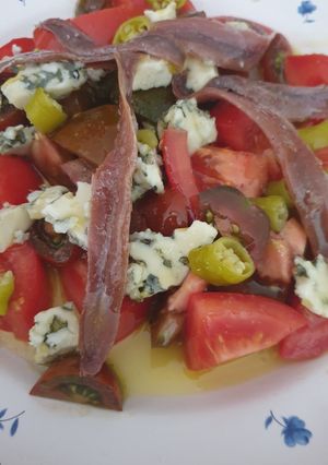 Una foto de Ensalada de tomates, queso azul y anchoas