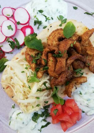 Una foto de Gyros de pollo con repollo encurtido exprés servido en mesa