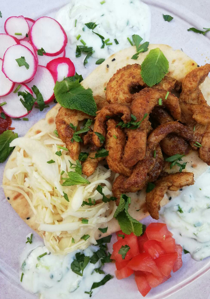 Una foto de Gyros de pollo con repollo encurtido exprés servido en mesa