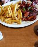 Alitas de pollo con salsa agridulce y papas fritas