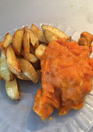 Una foto de Muslos de pollo en salsa y patatas asadas con especias