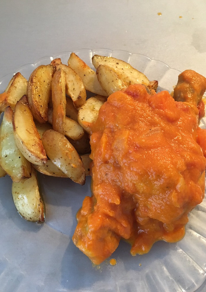 Una foto de Muslos de pollo en salsa y patatas asadas con especias