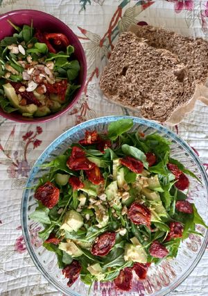 Una foto de Ensalada de rúcula, tomates secos, palta y frutos secos