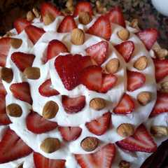 Una foto de Brownie con dulce de leche, crema, frutillas y almendras!!