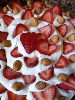 Una foto de Brownie con dulce de leche, crema, frutillas y almendras!!