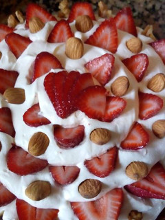 Una foto de Brownie con dulce de leche, crema, frutillas y almendras!!