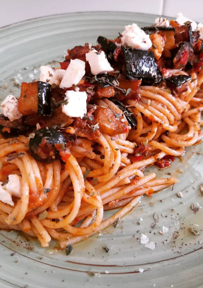Una foto de Espaguetis al pesto rojo con berenjenas y queso de cabra