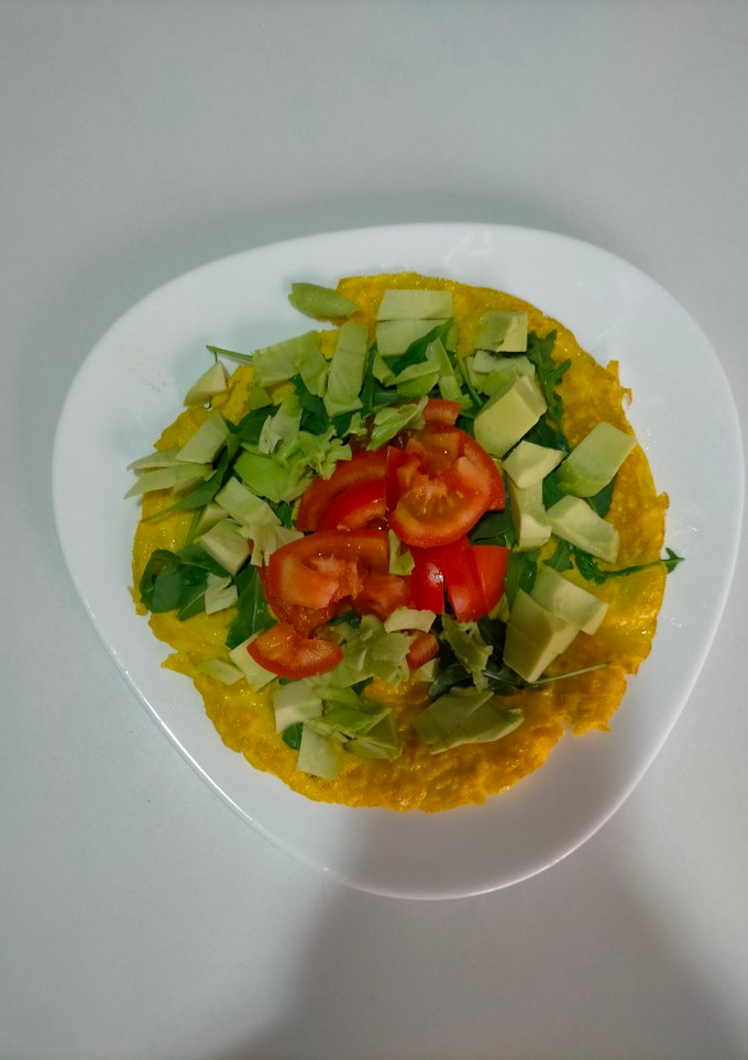 Una foto de Tortilla con rúcula, aguacate y tomate