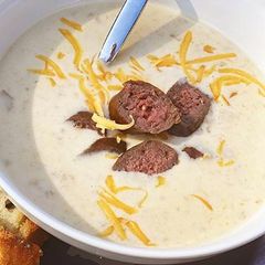 A picture of Oktoberfest Beer and Smoked Cheddar Soup with Fullblood Wagyu Beef Bratwurst.