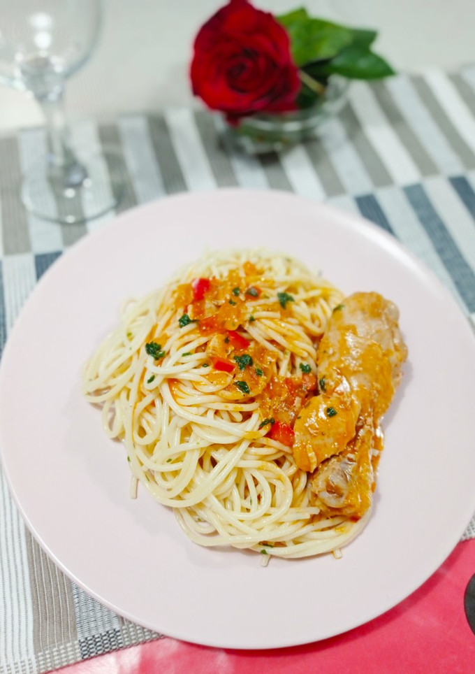 Una foto de Espaguetis y muslitos de pollo en salsa picante de tomate con cerveza