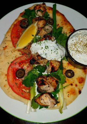 A picture of Mike's Grilled Chicken On Naan With Tzatziki Sauce.