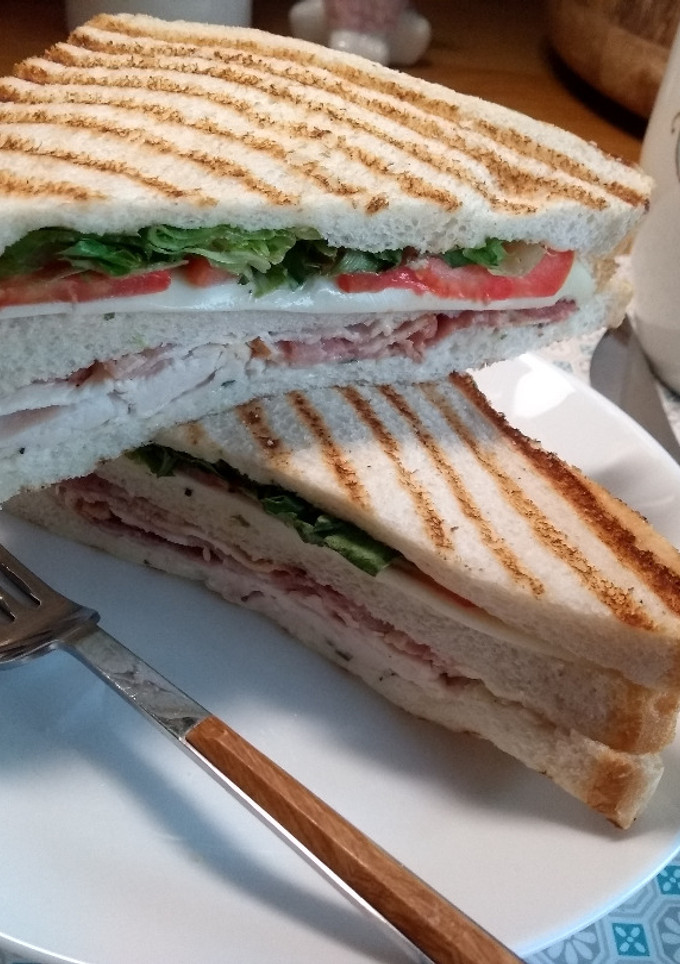 Una foto de Sándwiches triples tostado con pollo y Roast Beef crujiente