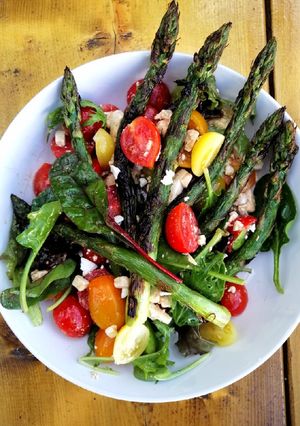 A picture of Grilled asparagus, tomato and feta salad.