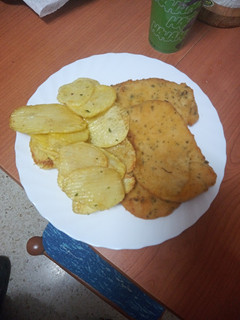 Una foto de Milanesas de pollo al ajillo con papas fritas onduladas