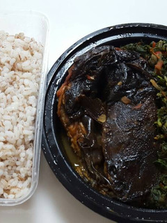 A picture of Ofada rice with vegetable sauce and dry fish.