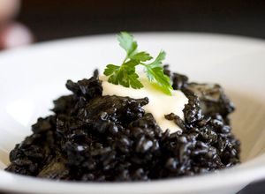 Una foto de Arroz negro con sepia y salsa alioli