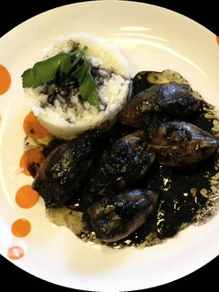Una foto de Calamares rellenos y en su tinta con guarnición de arroz
