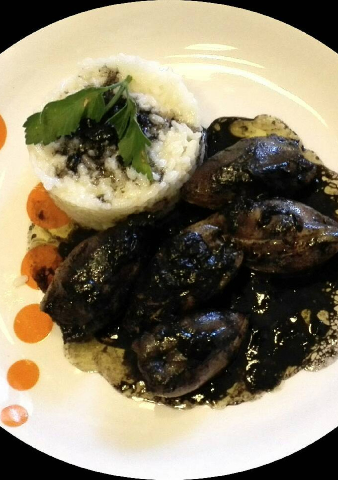 Una foto de Calamares rellenos y en su tinta con guarnición de arroz