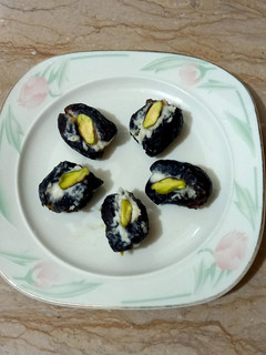 A picture of Dates filled with cream and pista.