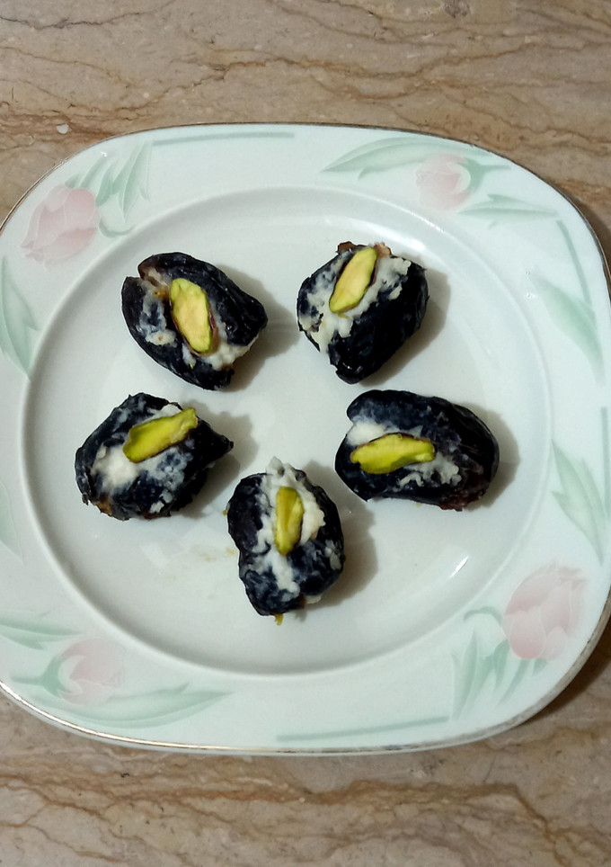 A picture of Dates filled with cream and pista.