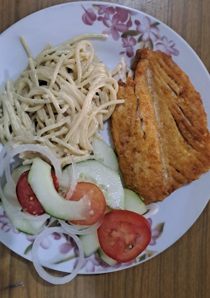 Una foto de Filete de dorado frito con ensalada fresca y espagueti con crema