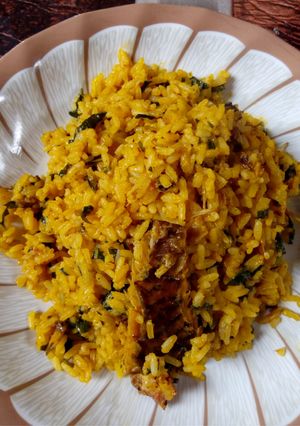 A picture of Local Jellof Rice With Palm Oil, Scent leaf and Dry Fish.