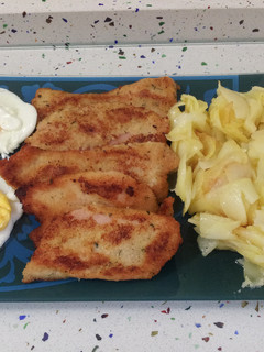 Una foto de Pechuga de pollo empanada con patatas y huevos fritos