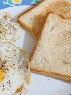 A picture of Sunny side up egg with toasted bread.