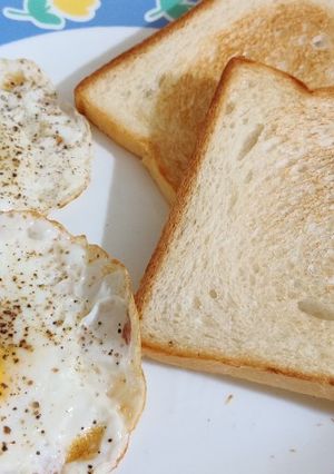 A picture of Sunny side up egg with toasted bread.